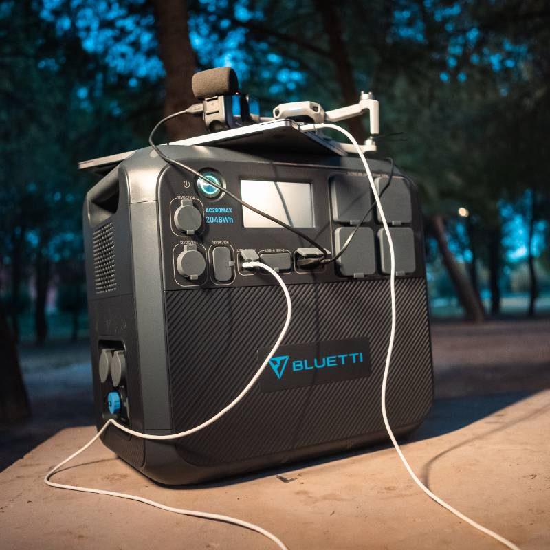 Bluetti AC200MAX Power Station set up for camping with various devices connected