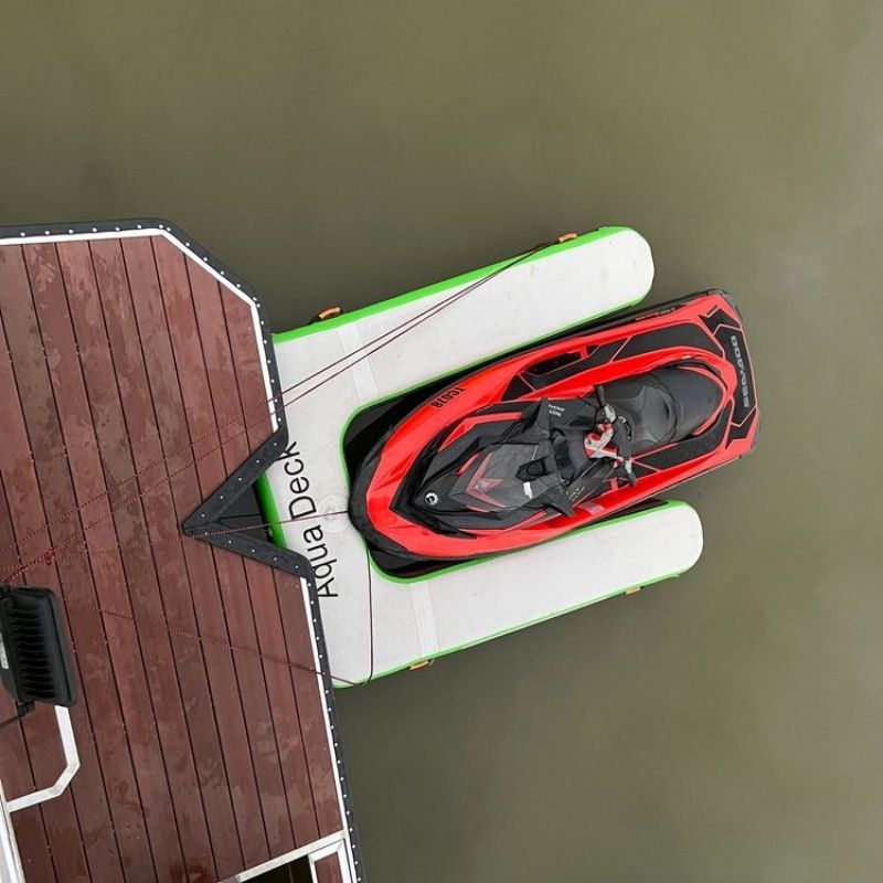 AquaDeck Inflatable Single Jetski Dock with red jetski securely docked in green water