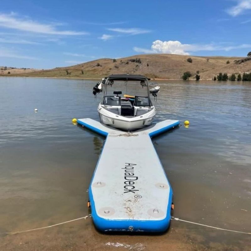 Aquadeck inflatable Y pontoon anchored in a river with scenic view