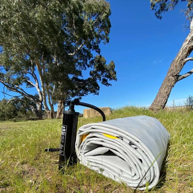 Bartlett 3m Circle Deck Water Hammock folded and ready for setup on a grassy field