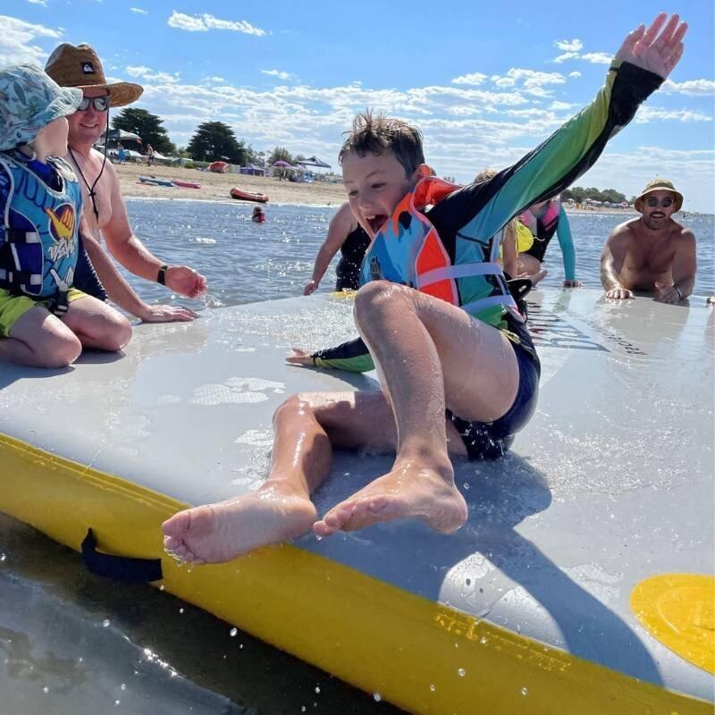 Kids playing on Bartlett 4m X 2m deck extender inflatable pontoon at the beach