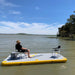 Person relaxing on Bartlett 4m X 2m deck extender inflatable pontoon with chairs on a lake