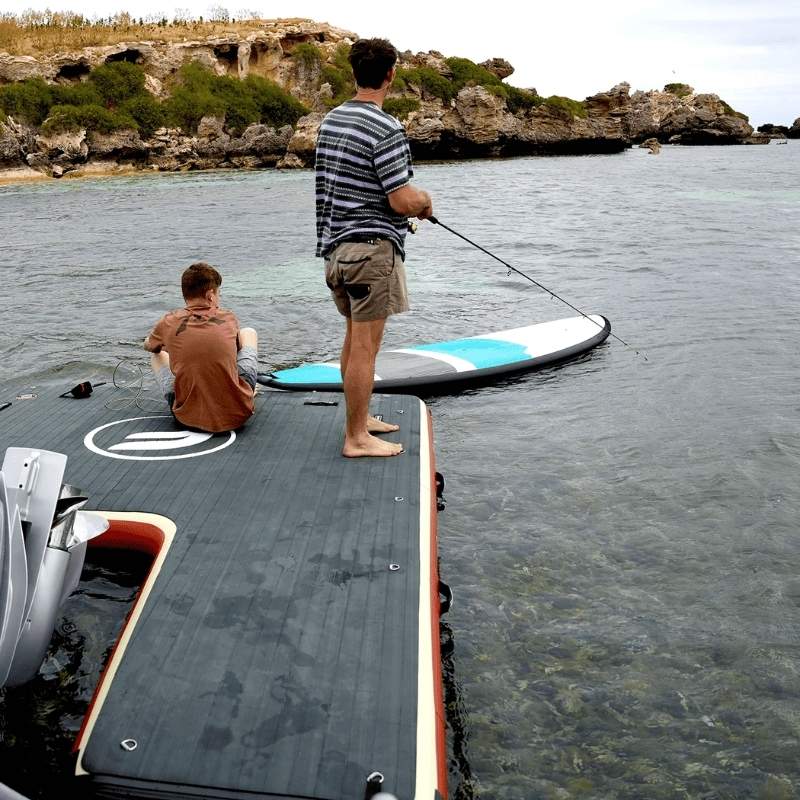 Floatables U-Dock inflatable boat dock with fishing setup near rocky shore