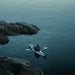 Oru Bay Folding Kayak exploring a river with surrounding rocks