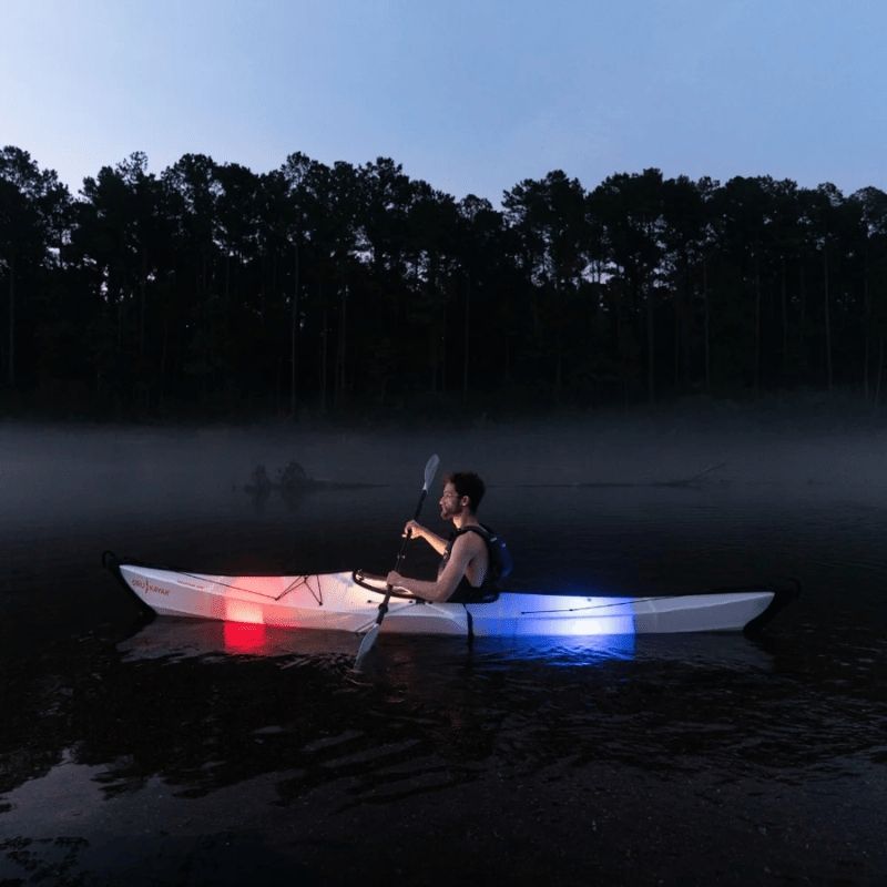 Oru Kayak Coast Xt on a night paddle with lights illuminating the water