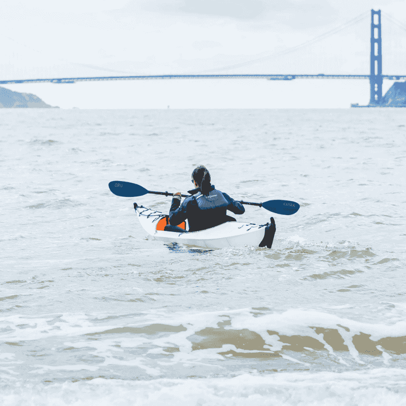 Oru Fiberglass Paddle for kayaking adventure with a bridge in the background