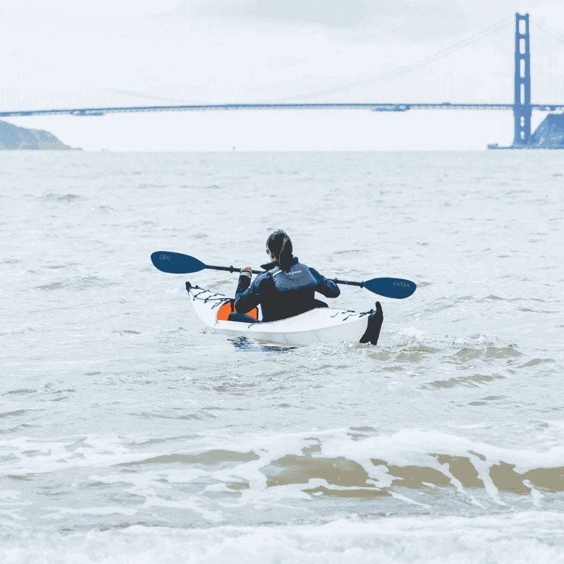 Kayaker using Oru fiberglass paddle while kayaking in the ocean