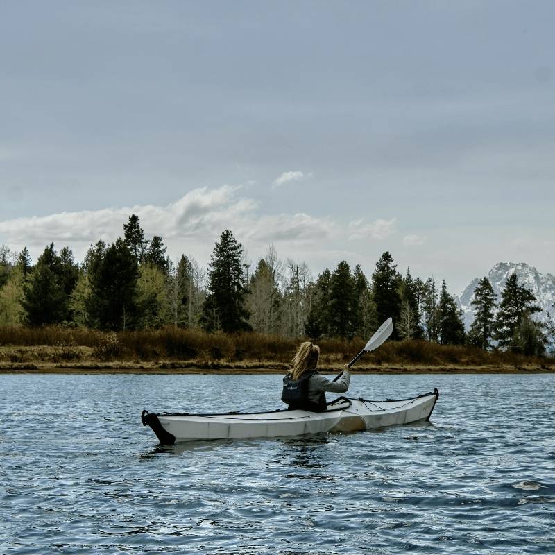 Oru Kayak Coast Xt foldable kayak paddling on calm waters surrounded by nature