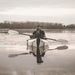 Woman paddling Oru Kayak Inlet on a serene lake during a calm day