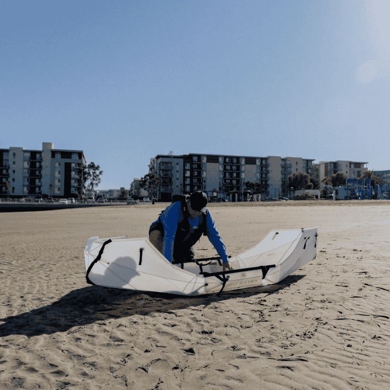 Oru Lake kayak being prepared on a sandy shore before a lake paddle