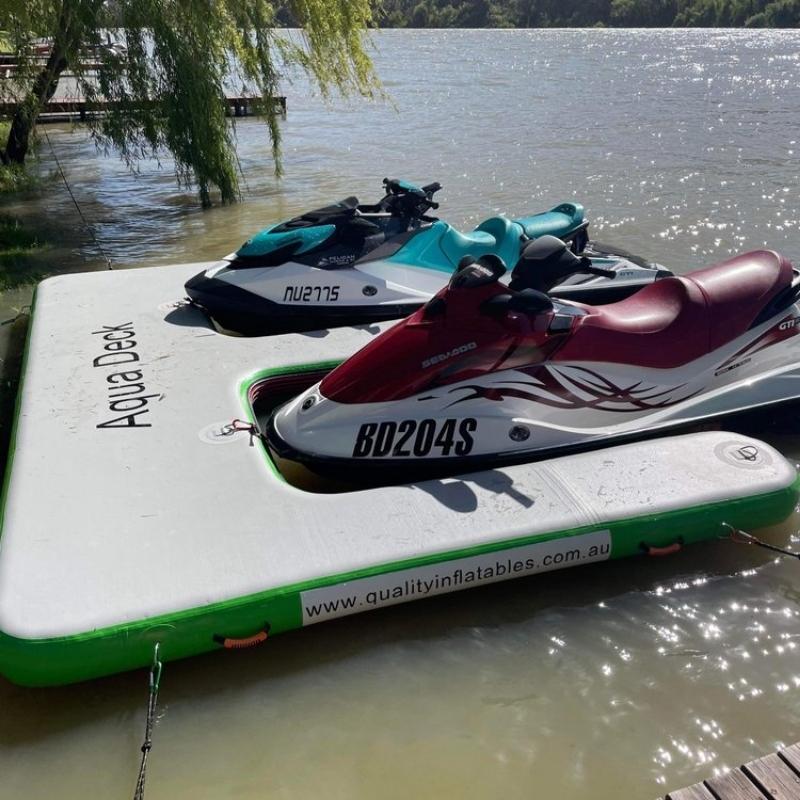 Green portable jetski dock by Aquadeck with a scenic backdrop