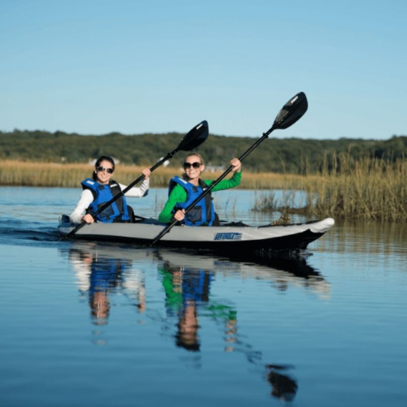 Two women kayaking on a calm lake in Sea Eagle 385ft FastTrack